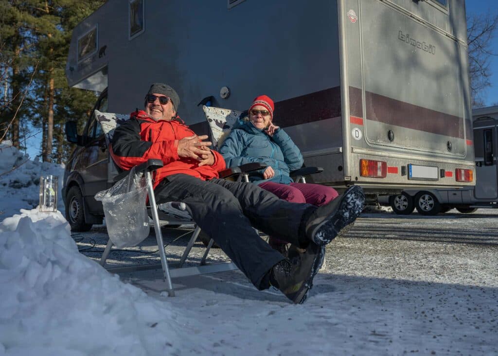 Par njuter av vintercamping vid First Camp Lugnet Falun, omgivna av snö och natur